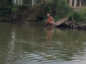 Local older man sitting by the river